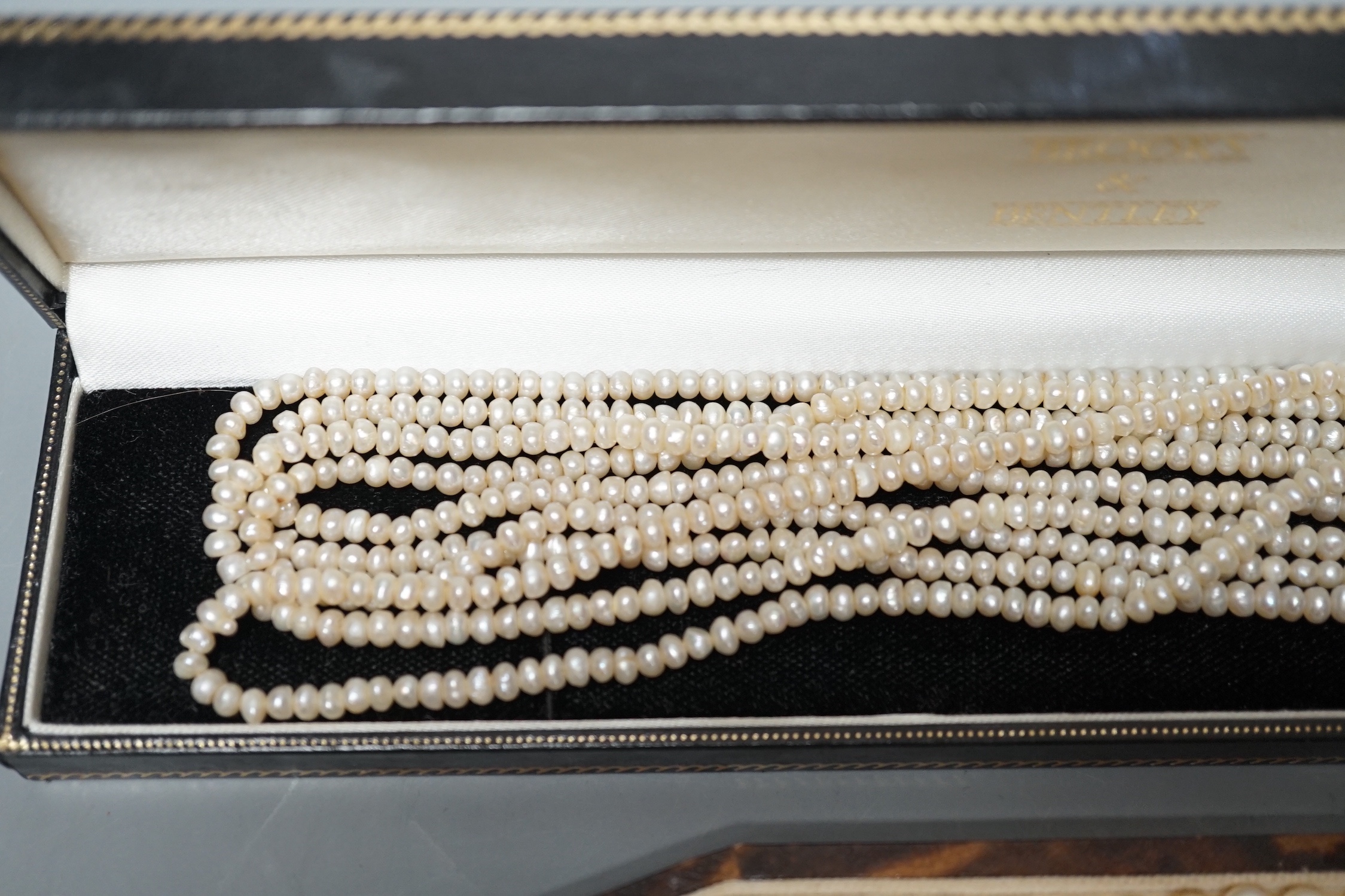 A single strand cultured pearl necklace, with sterling clasp, 44.5cm and a quadruple strand baroque seed pearl necklace, with gilt metal clasp, 42cm.